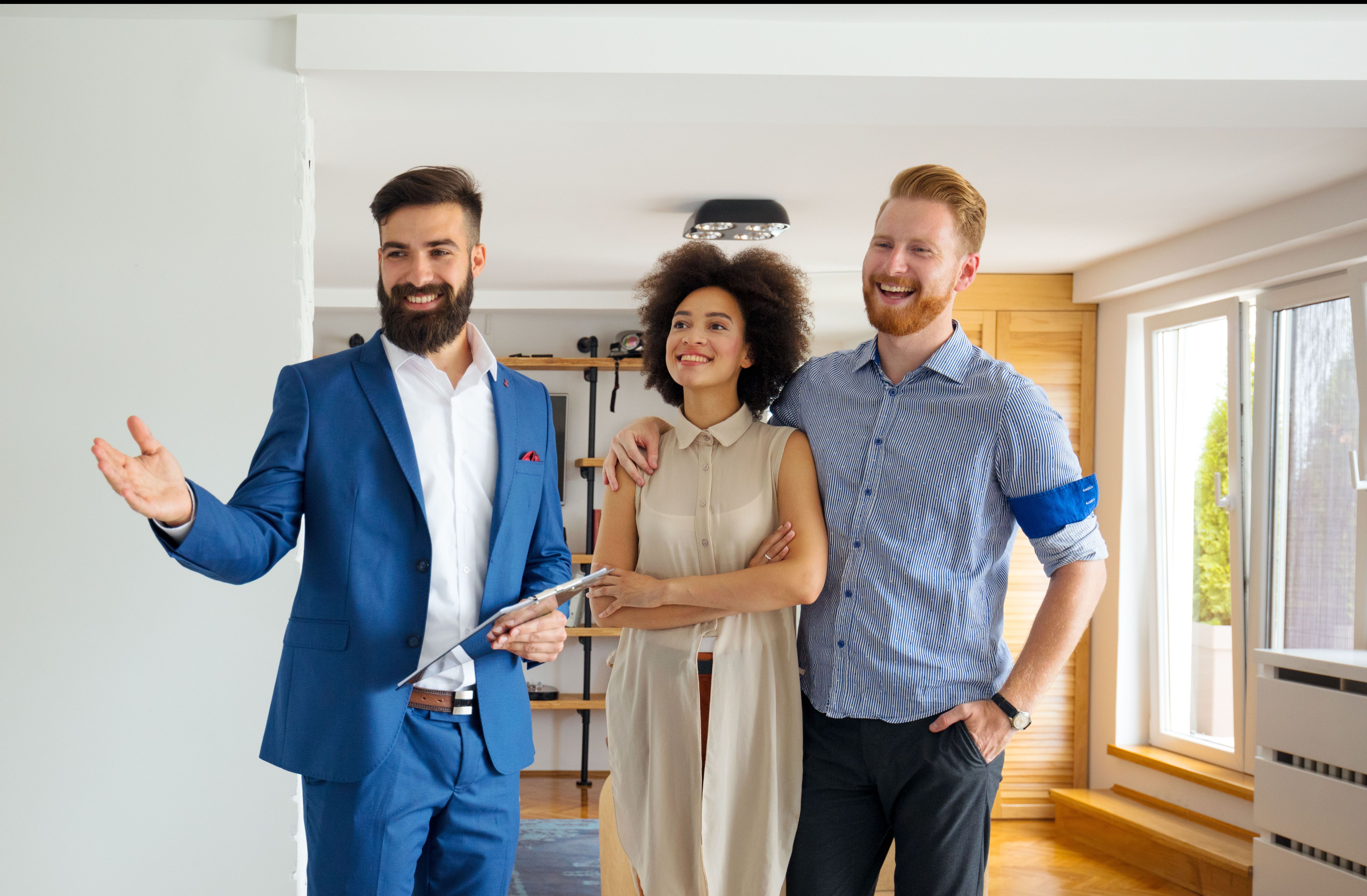 Cheerful real estate agent guiding prospective buyers through a property.